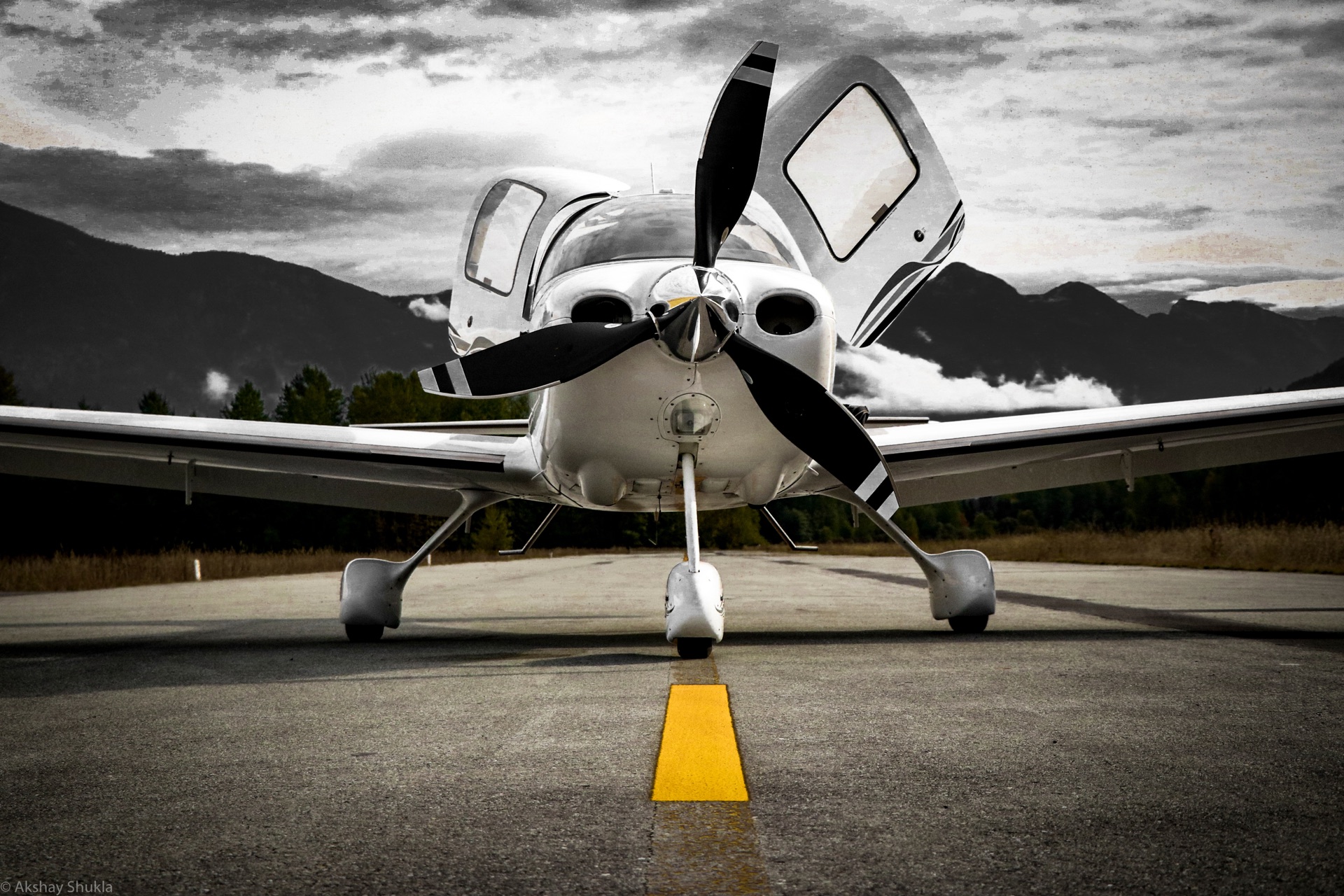 Cirrus head-on on a runway centerline, dramatic monochrome sky